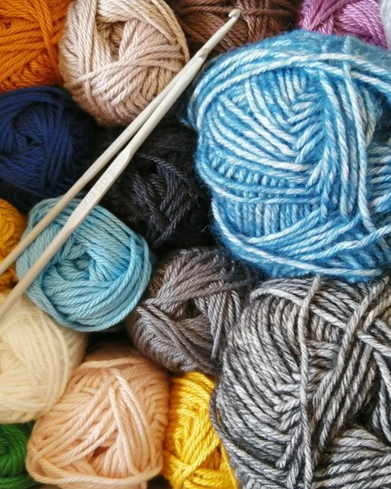 Finished animal coasters on a table with leftover yarn and geometry tiles